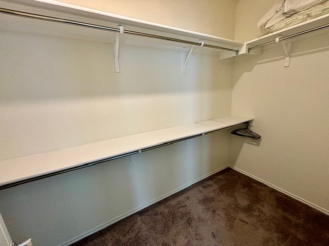 Huge Master walk-in closet with double-hanging shelving units, and amble room for shoes.