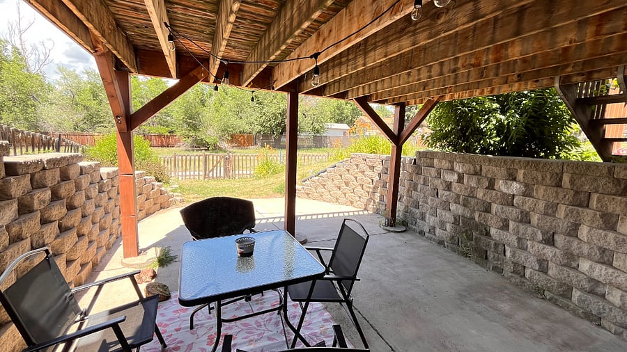 Basement patio with a table, chairs and hanging lights