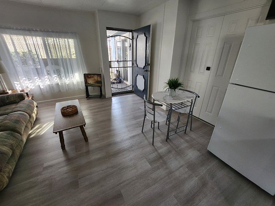 View from inside kitchen toward front entrance with security screen door