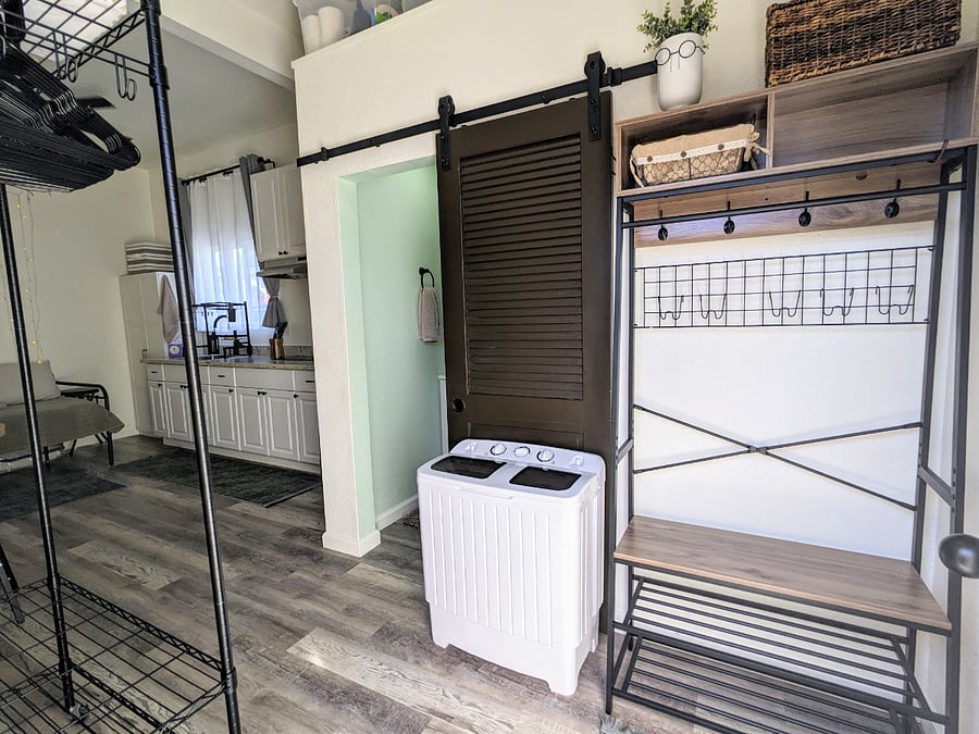 Hanging wardrobe to the left has convenient storage hooks, storage bins, & hangers. There's bonus storage space above the bathroom, with an open bin for you to use.
