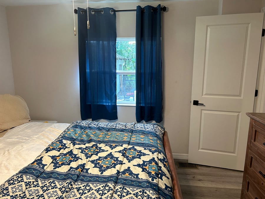 King bedroom with ceiling fan and 36 in Smart TV and bathroom.