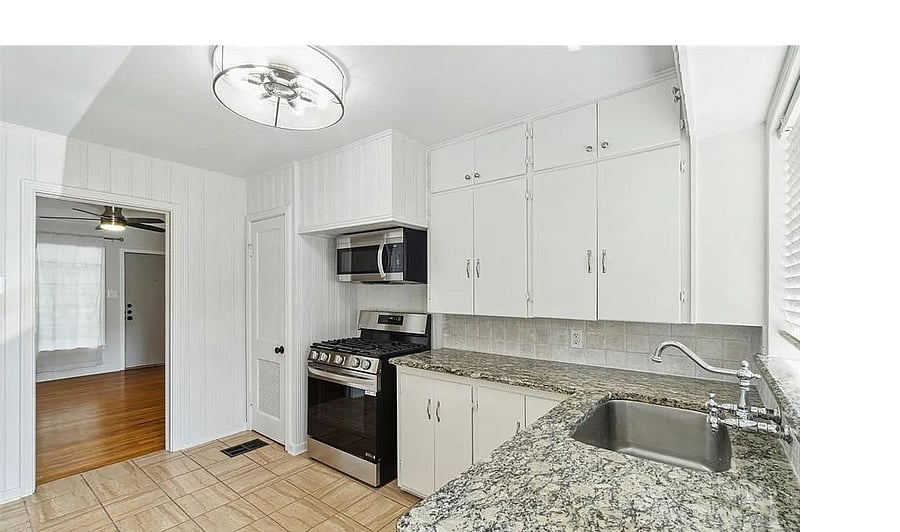 Modern, clean kitchen with granite countertops and stainless steel appliances.