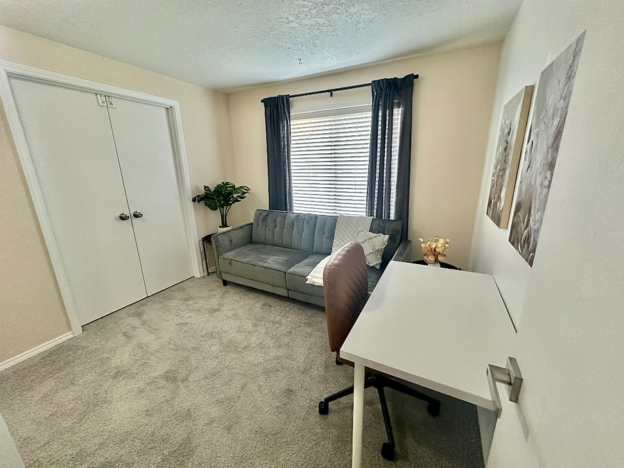 Designated workspace that has a futon couch/bed (full size) and a working desk.