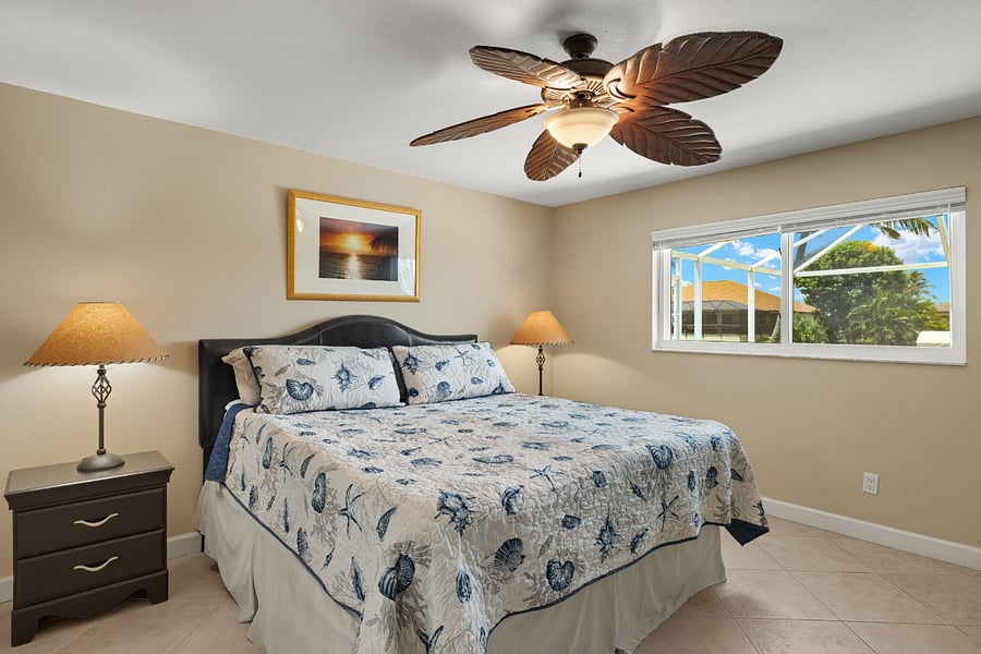 Master bedroom with king sized bed overlooking lanai and pool