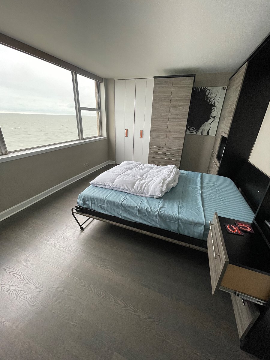 Main Bedroom - Queen Size Murphy Bed, Memory Foam Mattress with side tables, light, and storage.