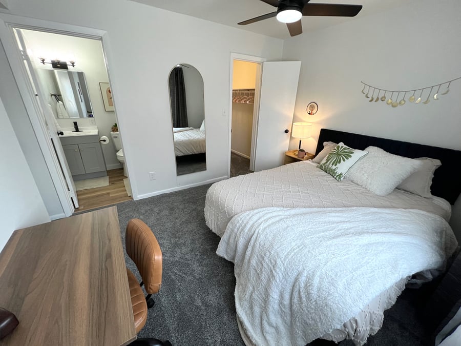 Bedroom with queen size bed and desk.
