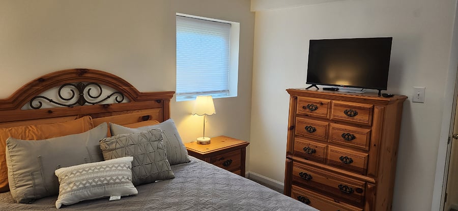 Primary bedroom with queen bed, quality linens, and ample natural light.