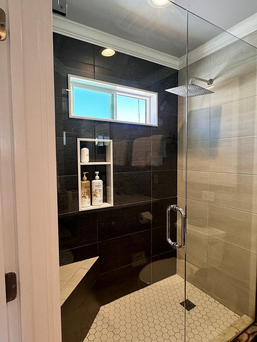 Full size shower with glass doors and corner bench seat