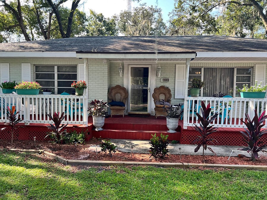 Photo of front of the house.  One story residence with hot tub and bar area on the deck, enclosed patio with large screen television. 