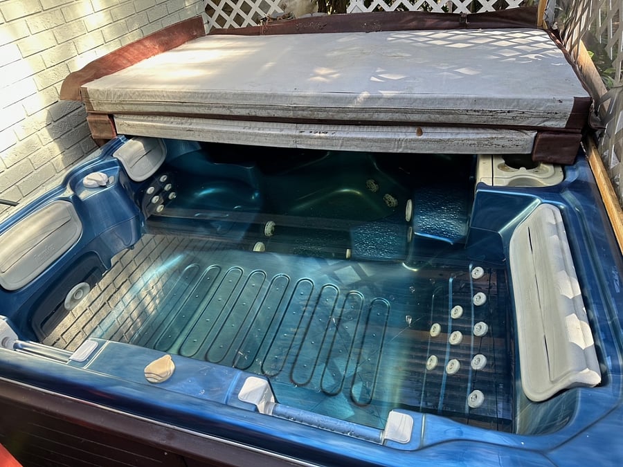 Six person hot tub available on a deck with a private dining area and a bar.