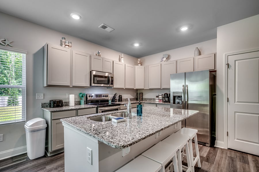 Sleek, fully stocked kitchen featuring new stainless steel appliances, granite countertops, a huge island, and plenty of cabinet space for all your culinary needs.