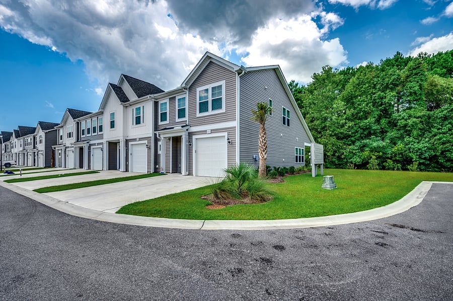 Inviting front exterior with a large side yard and convenient guest parking spots, making it easy for visitors to come and go.