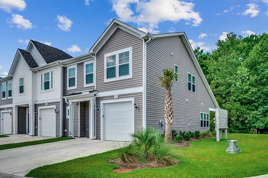 Inviting front exterior with a large side yard and convenient guest parking spots, making it easy for visitors to come and go.