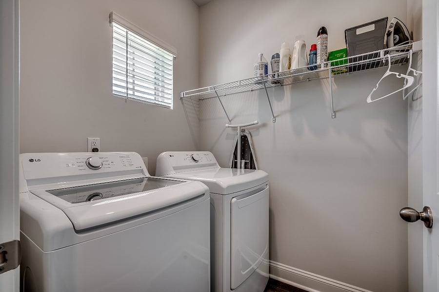 Spacious walk-in laundry room with washer/dryer and ample shelf space for all your laundry essentials.