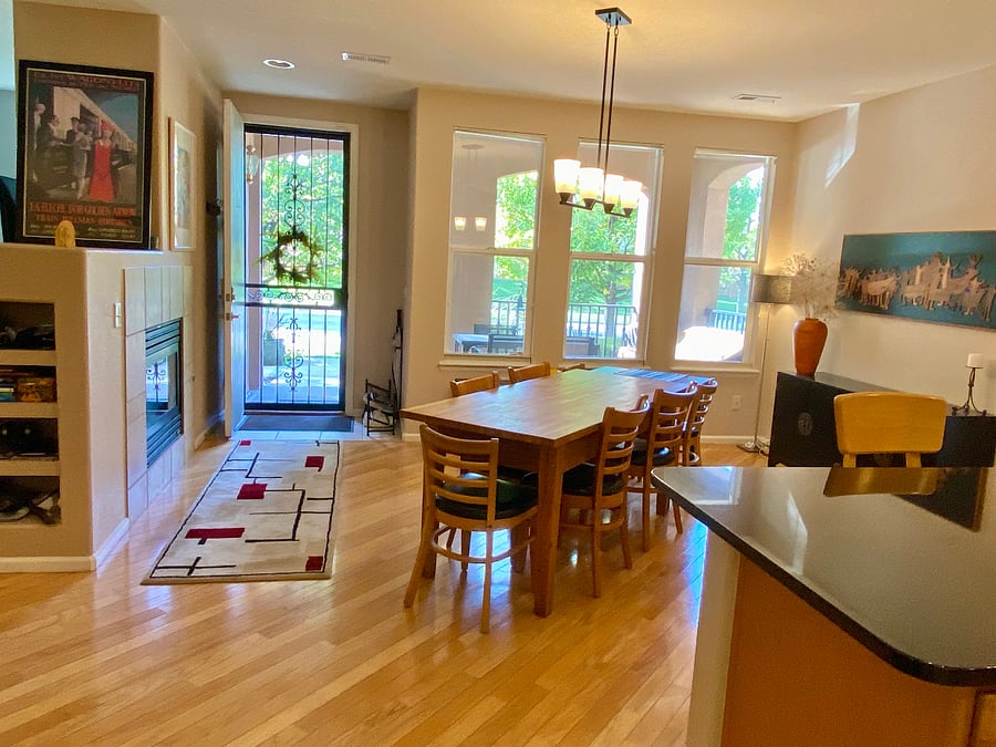The dining area adjoins the kitchen. It has a fireplace and large windows that open to the covered front porch.