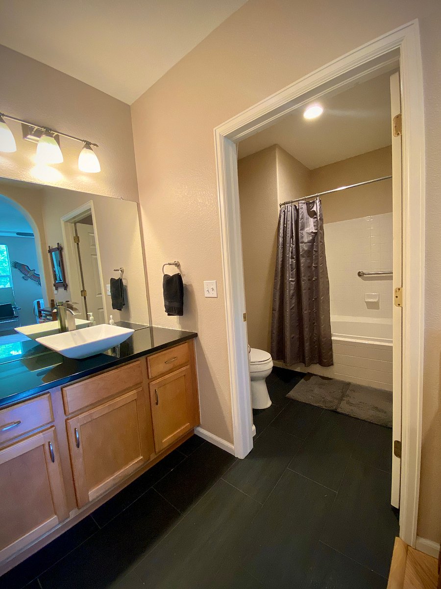 The en suite bath has a large granite-top vanity and an oversized tub/shower, with toilet separate from the vanity. The additional full bath is by the living room.