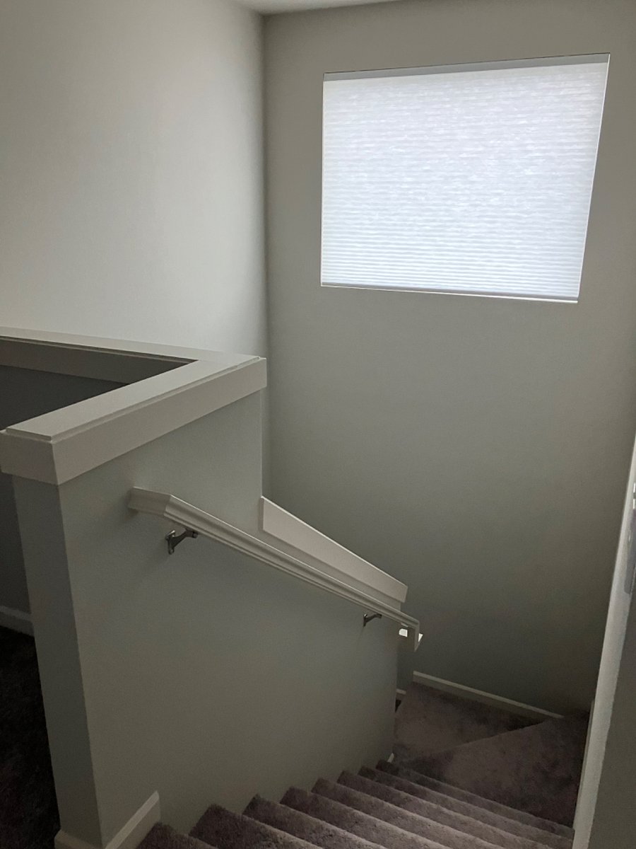 large window ablve stairwell with remote operated blinds
