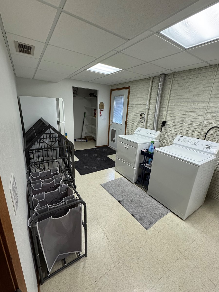 Laundry room with a doggy door and dog kennel
