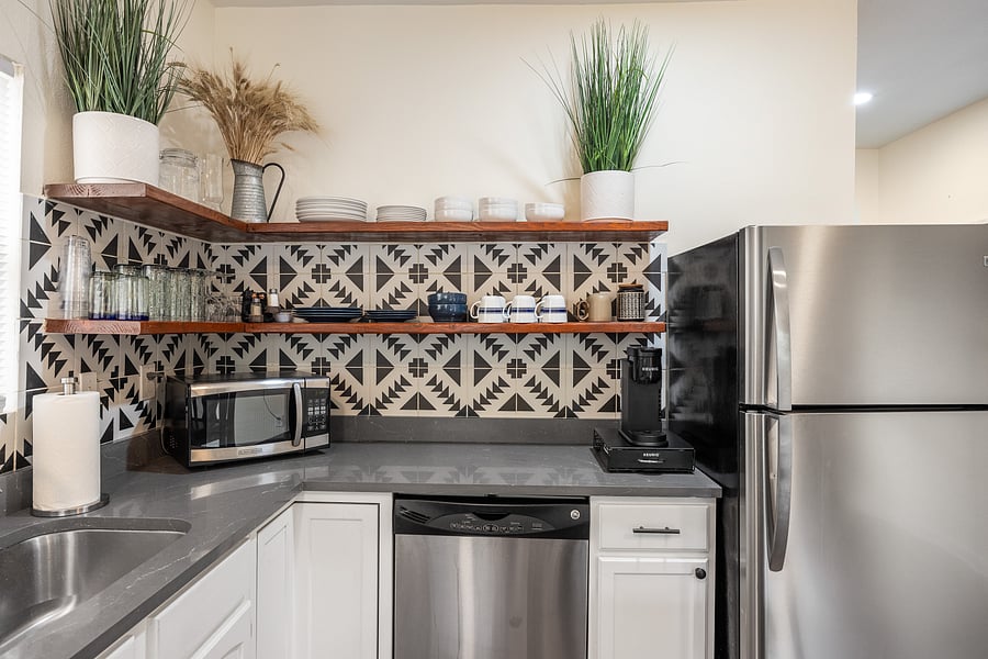 Kitchen with plenty of dishes, cookware and spices. There is also a Keurig coffee maker