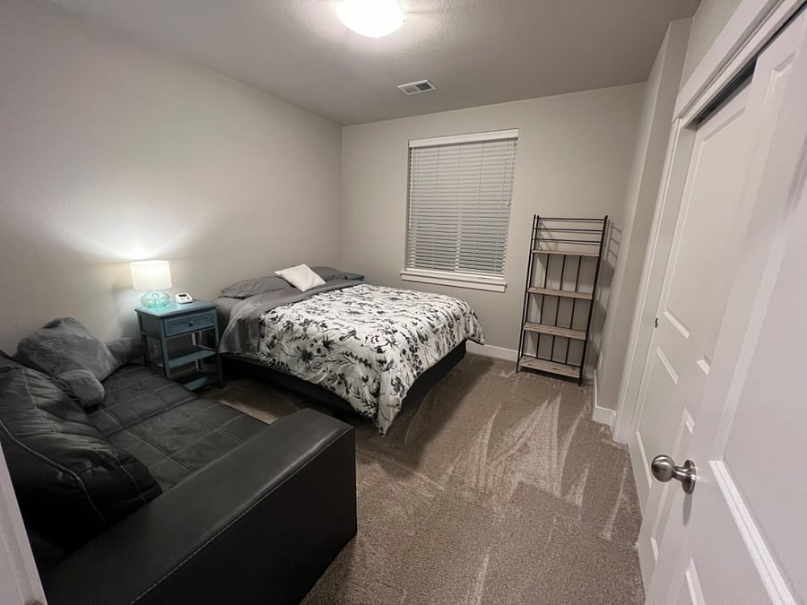 Cozy bedroom located in basement includes private seating area.