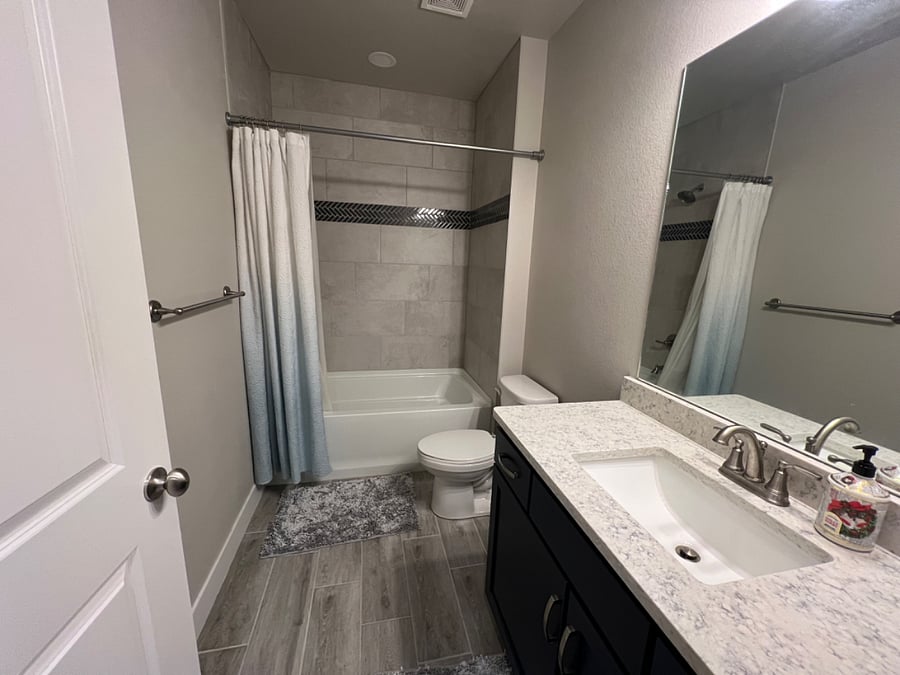 Large full size bathroom with soaking tub located in basement.
