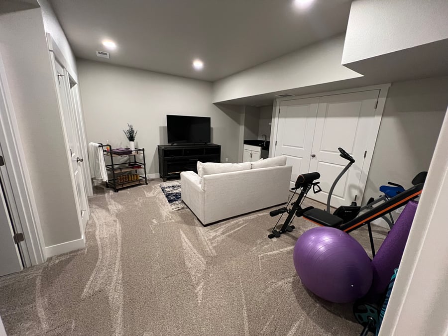 Private basement with 65 TV, wet bar, and exercise equipment. Basement also boasts a full bath, bedroom, and storage.