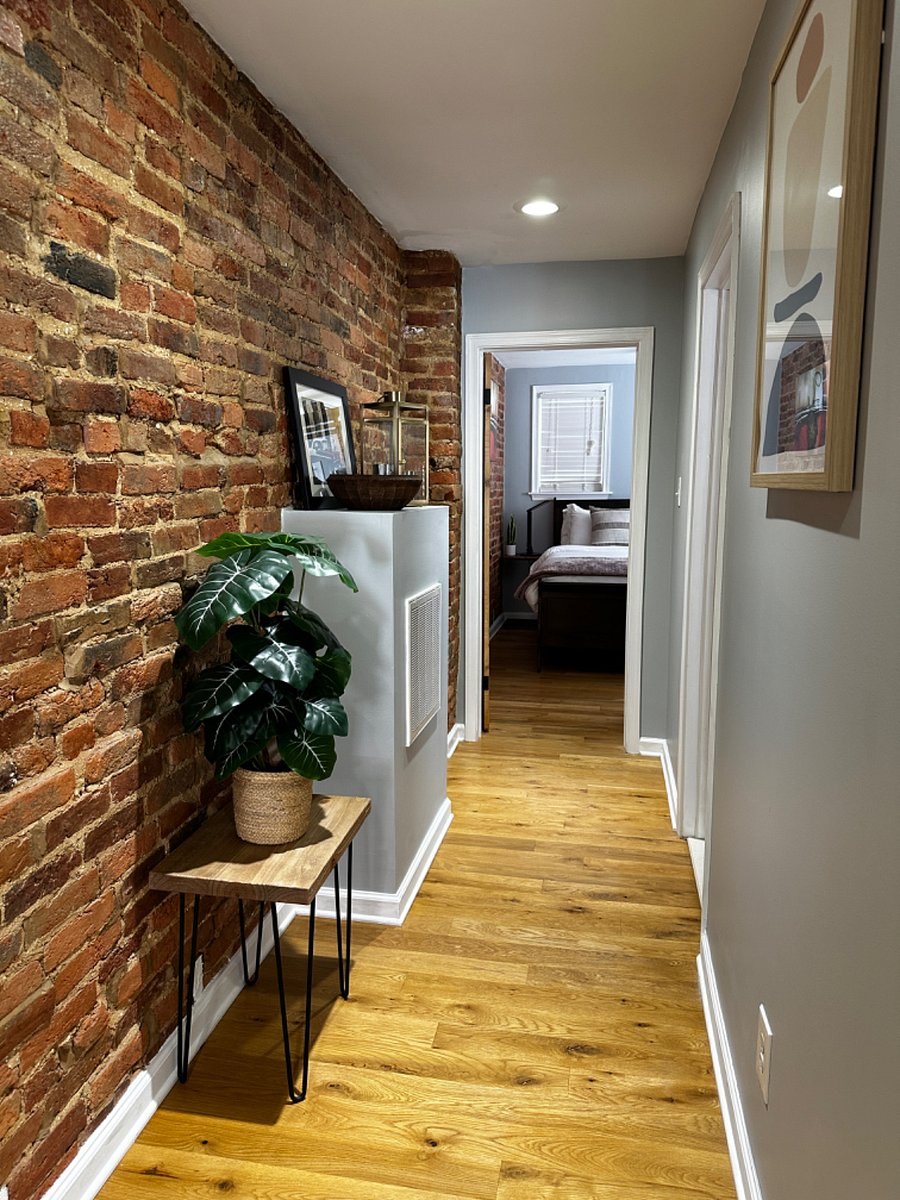 Upstairs hallway with exposed brick. Stairwell landing is directly off secondary bedroom.