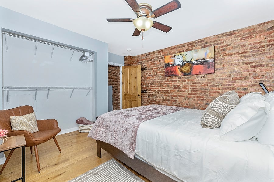 Primary bedroom with queen size bed, dresser, ceiling fan & room darkening blinds.