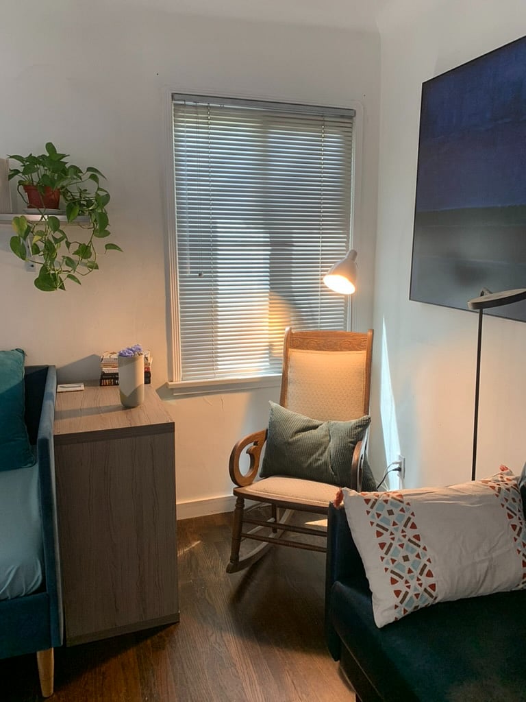 Reading nook with antique rocking chair. Bookshelf for your current reads and morning coffee.