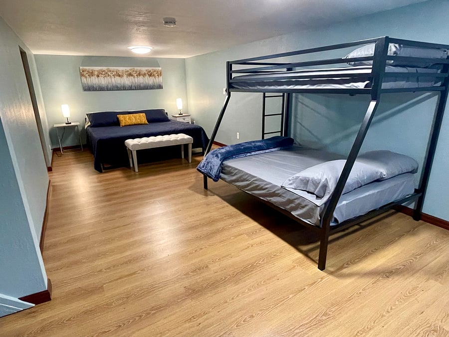 Downstairs bedroom with king bed, and a twin over full bunkbed.