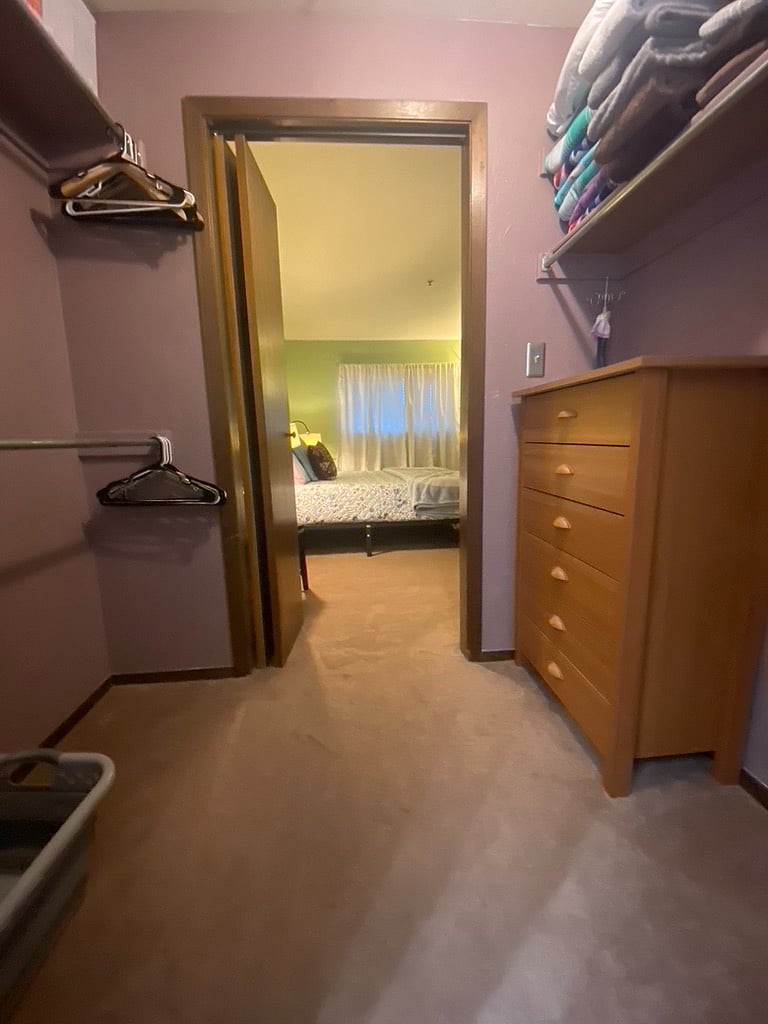 Walk through closet in primary bedroom, leading to connected full bath