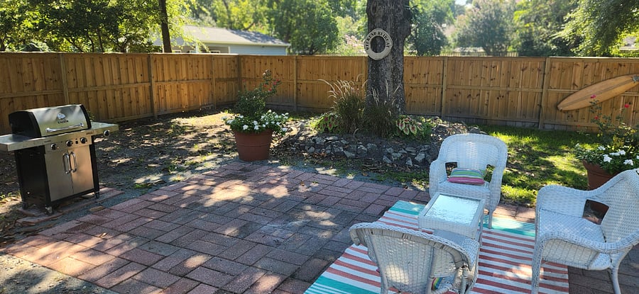 Spacious fenced backyard with gas char grill and shade under the 100-year-old Magnolia tree.