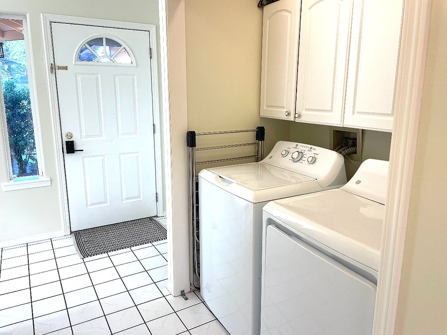 Laundry area in hallway with view of front door.