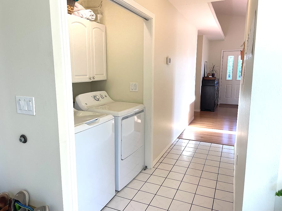 Laundry area in hallway with view of backdoor.