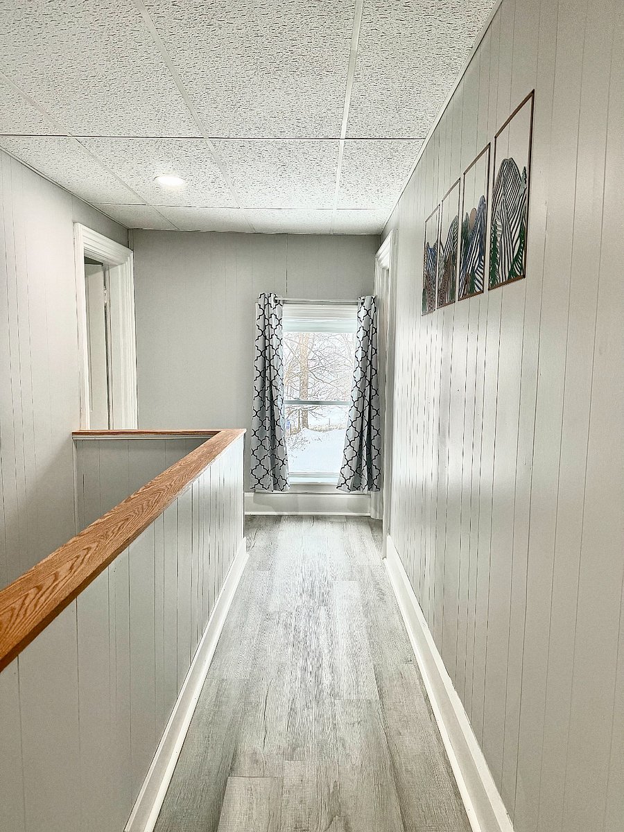 This bright and airy hallway is filled with natural light, with all windows featuring black-out shades for added comfort and privacy.