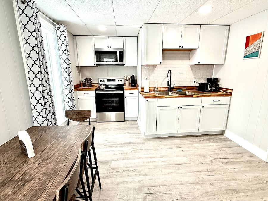 The kitchen features a stainless steel range and microwave, complemented by beautiful butcher block countertops, offering both functionality and style for your cooking and meal prep needs.