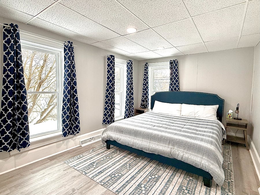 This spacious master bedroom features a king-size bed, bathed in natural light with black-out shades for a perfect balance of brightness and privacy.