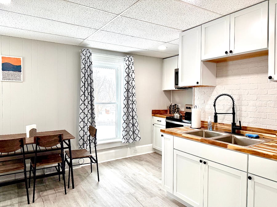 This bright and airy kitchen is filled with natural light, highlighting the beautiful shaker cabinets that offer plenty of storage space. The modern pull-out faucet adds a stylish touch, making this kitchen both functional and inviting.