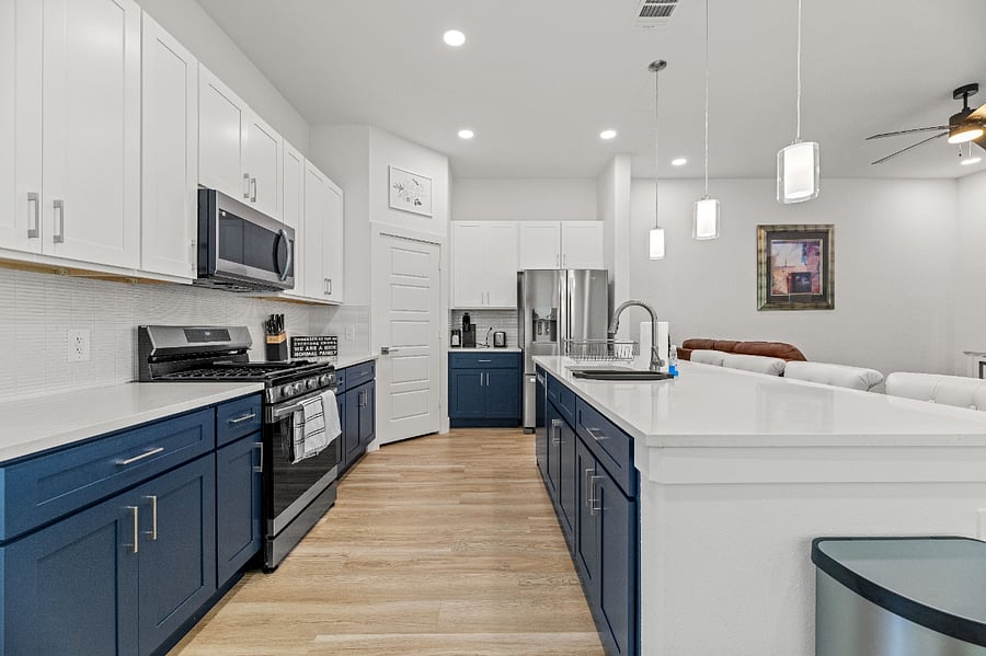 Kitchen with all new appliances. Five-burner range with air fryer option, refrigerator with French doors, microwave, and dishwasher.