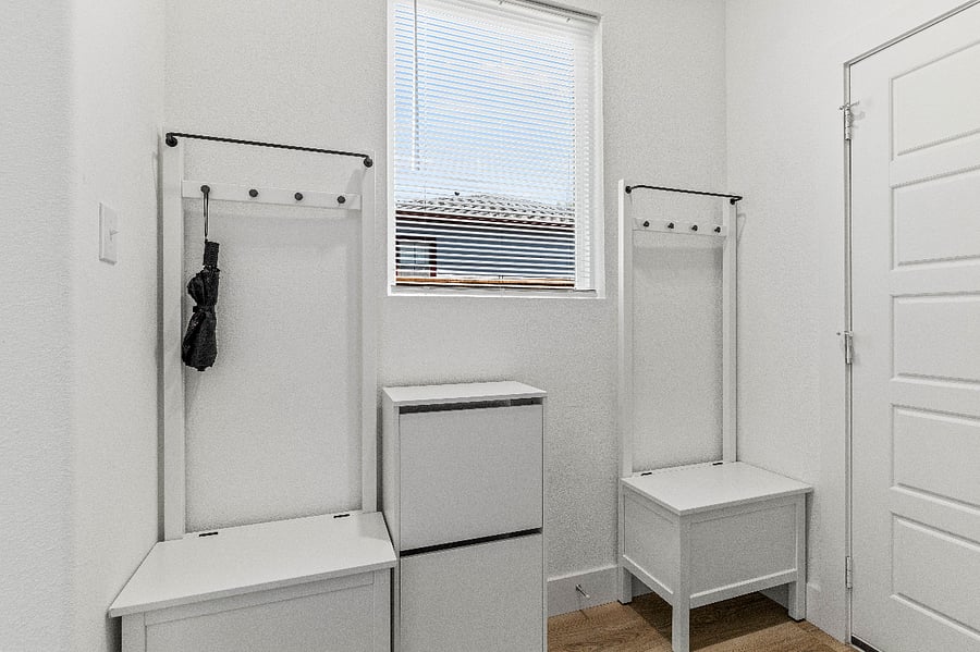 Mud room area is located between the garage and front door and offers a shoe cabinet, and benches with storage.