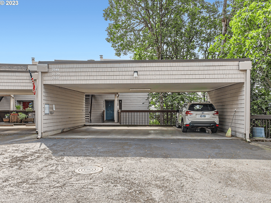 Covered car port at the base of the stairs to the condo