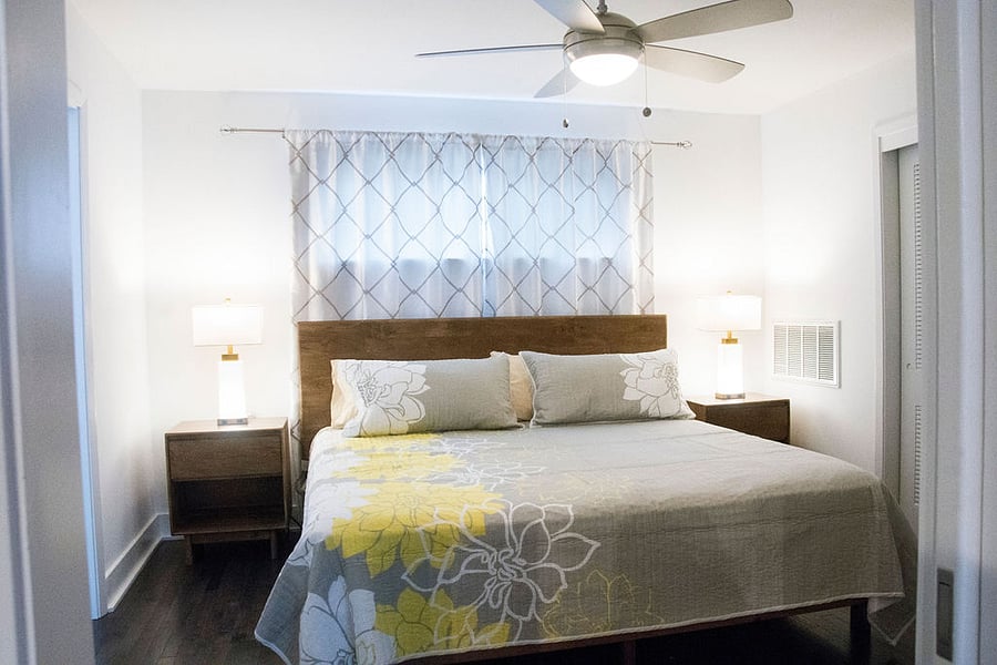 Bedroom with king size bed, 2 night stands with lamps and dresser.