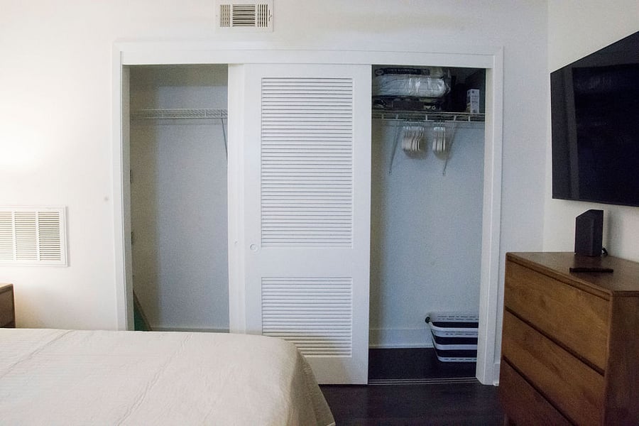 Large closet with hangers and laundry basket.