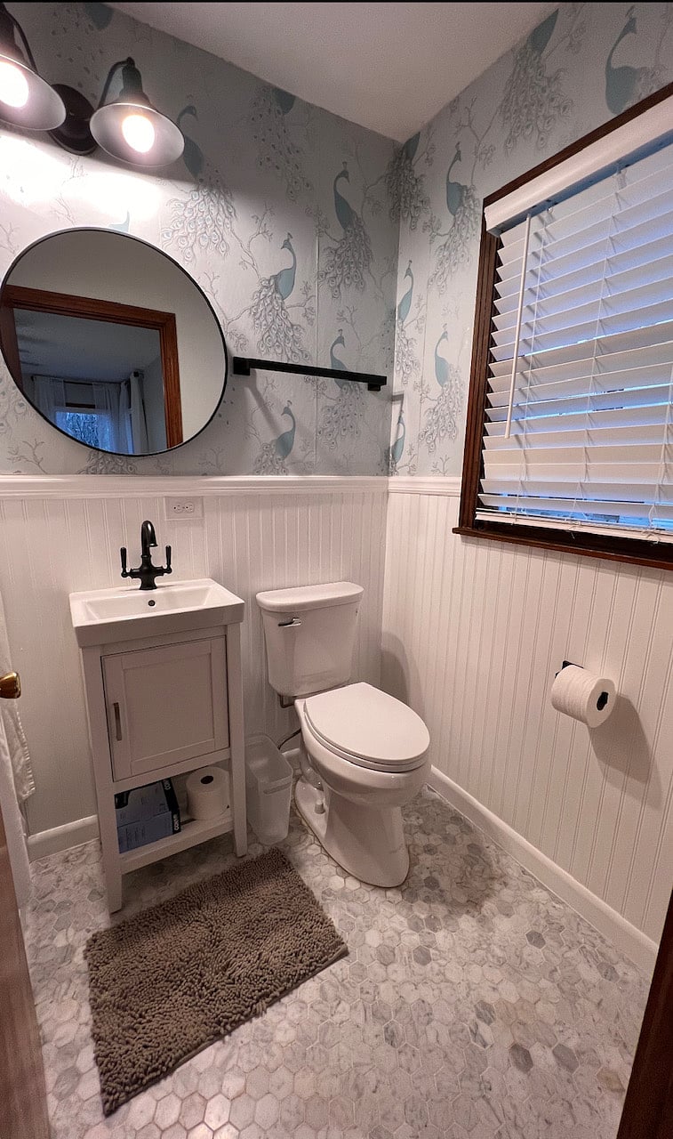Primary bathroom w/ peacock wallpaper (obsessed with lol). Also has a working heater :)
