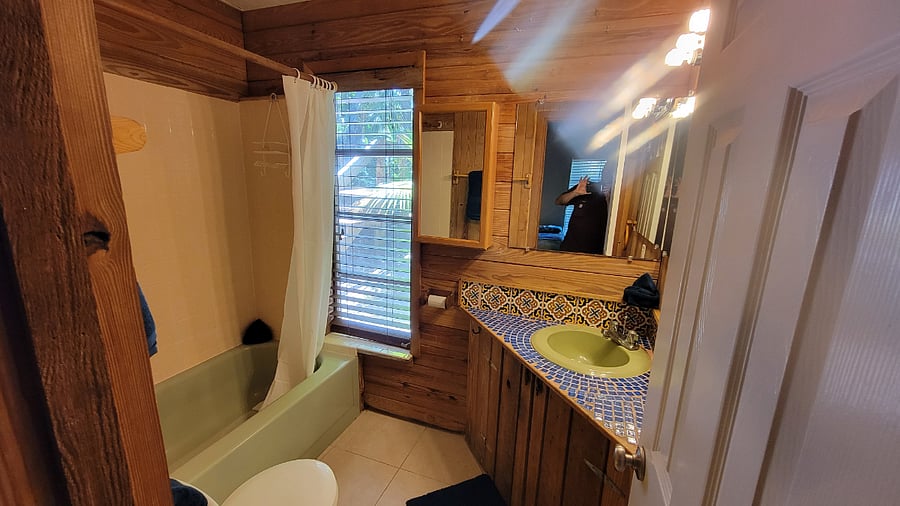 Full tile bath with vanity, medicine cabinet, tub with shower and hand shower. Equipted with towels, paper, small body wash and shampoo.