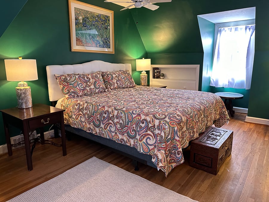 Large, light-filled primary bedroom with king-size bed and sitting area
