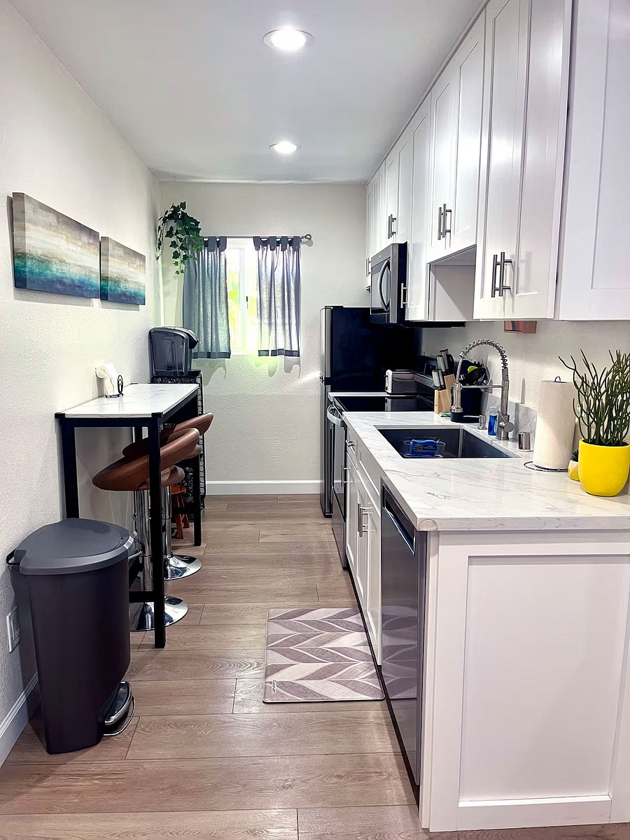 The kitchen walkway is shown with the table and coffee station.