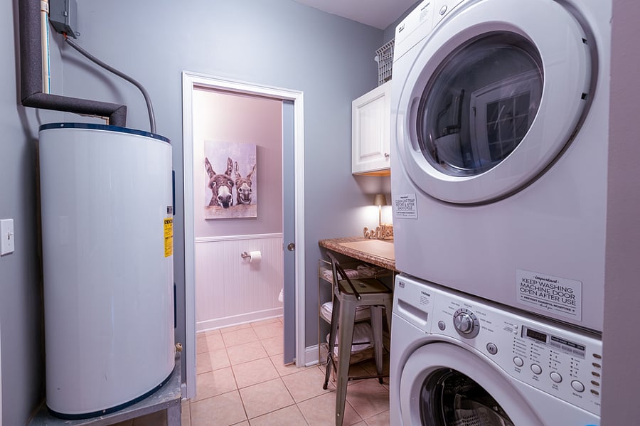 Laundry area. Hot water heater out of the way. LG washer/dryer. Desk workspace w/light and portable fan. Hangers, cleaning supplies and extra towels will be stored in this area.