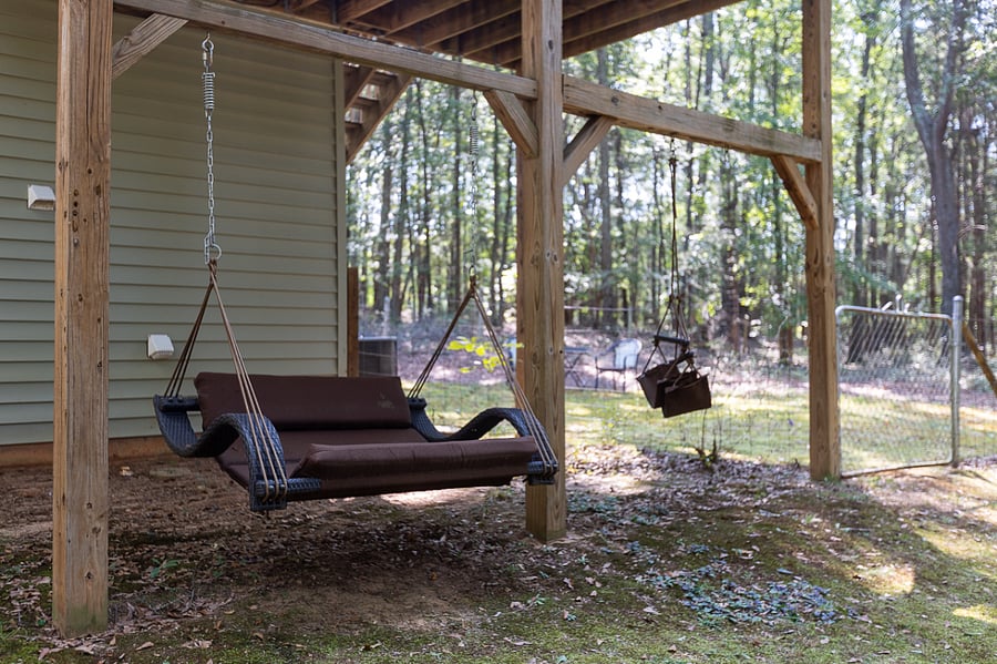 Under balcony, HangZ love seat swing. Access to fenced backyard. Peaceful place to relax.