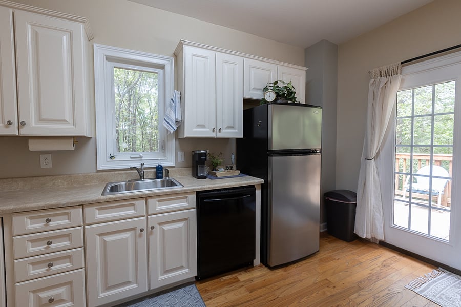Kitchen view. Full size fridge. Crank open kitchen window. You will love this in cooler months. Vacuum, trash can, mop, broom, step stool are located to the right of the fridge (out of the way).